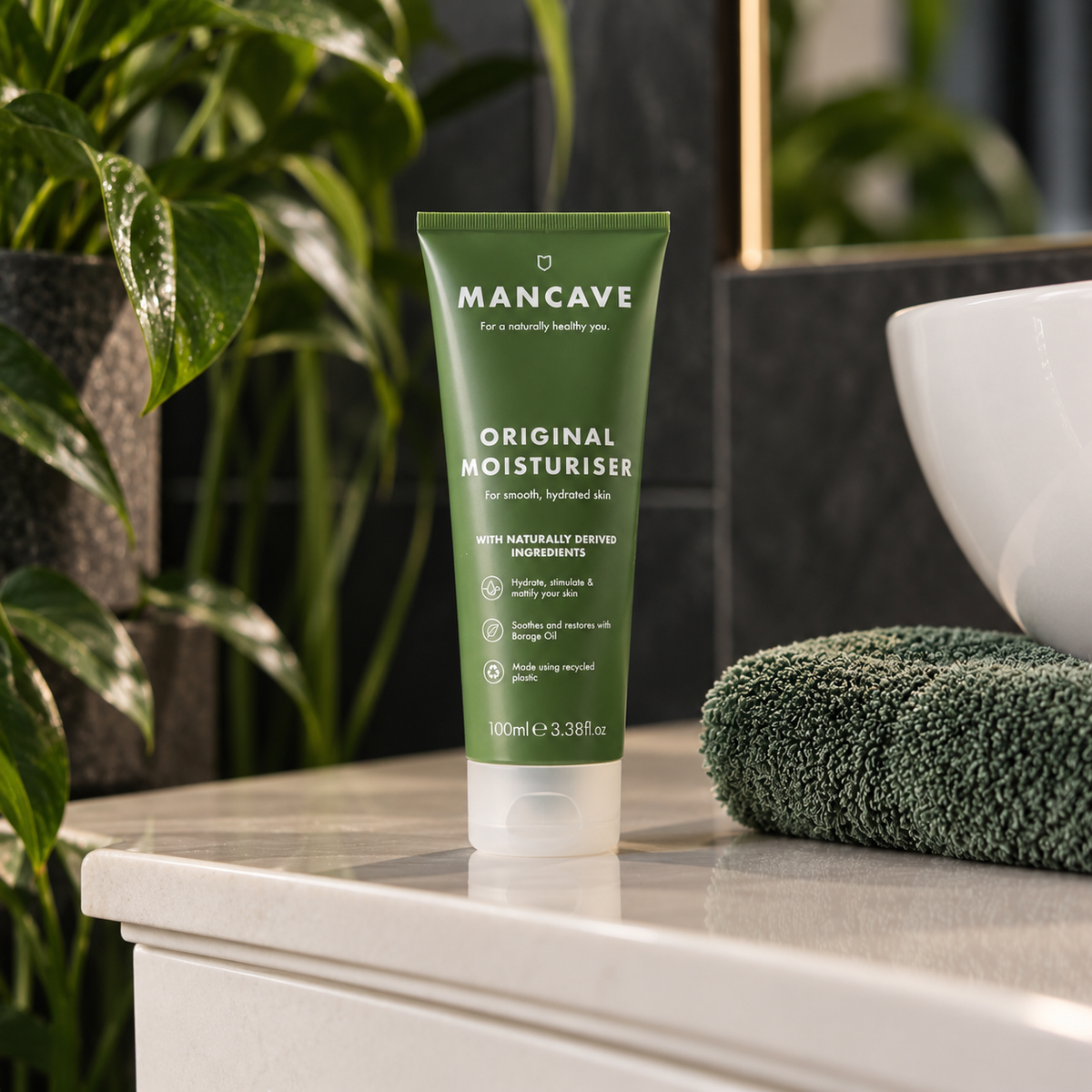 ManCave Original Moisturiser på baderomsbenken sammen med håndkle og grønne planter