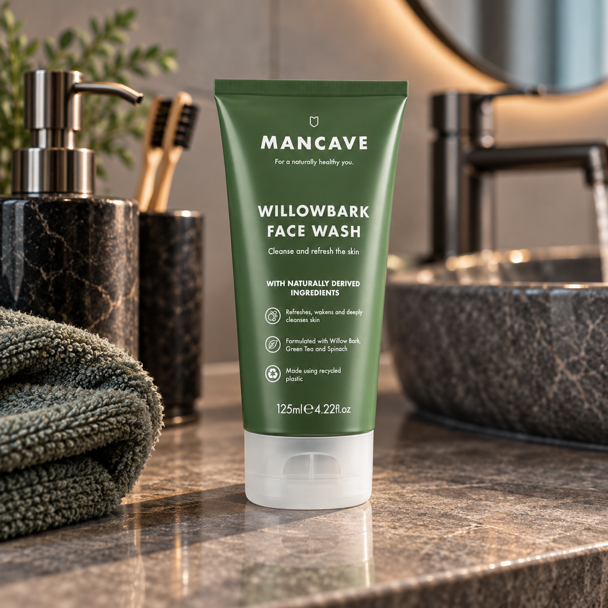 ManCave Willowbark Face Wash på baderomsbenken sammen med håndkle og hudpleieprodukter
