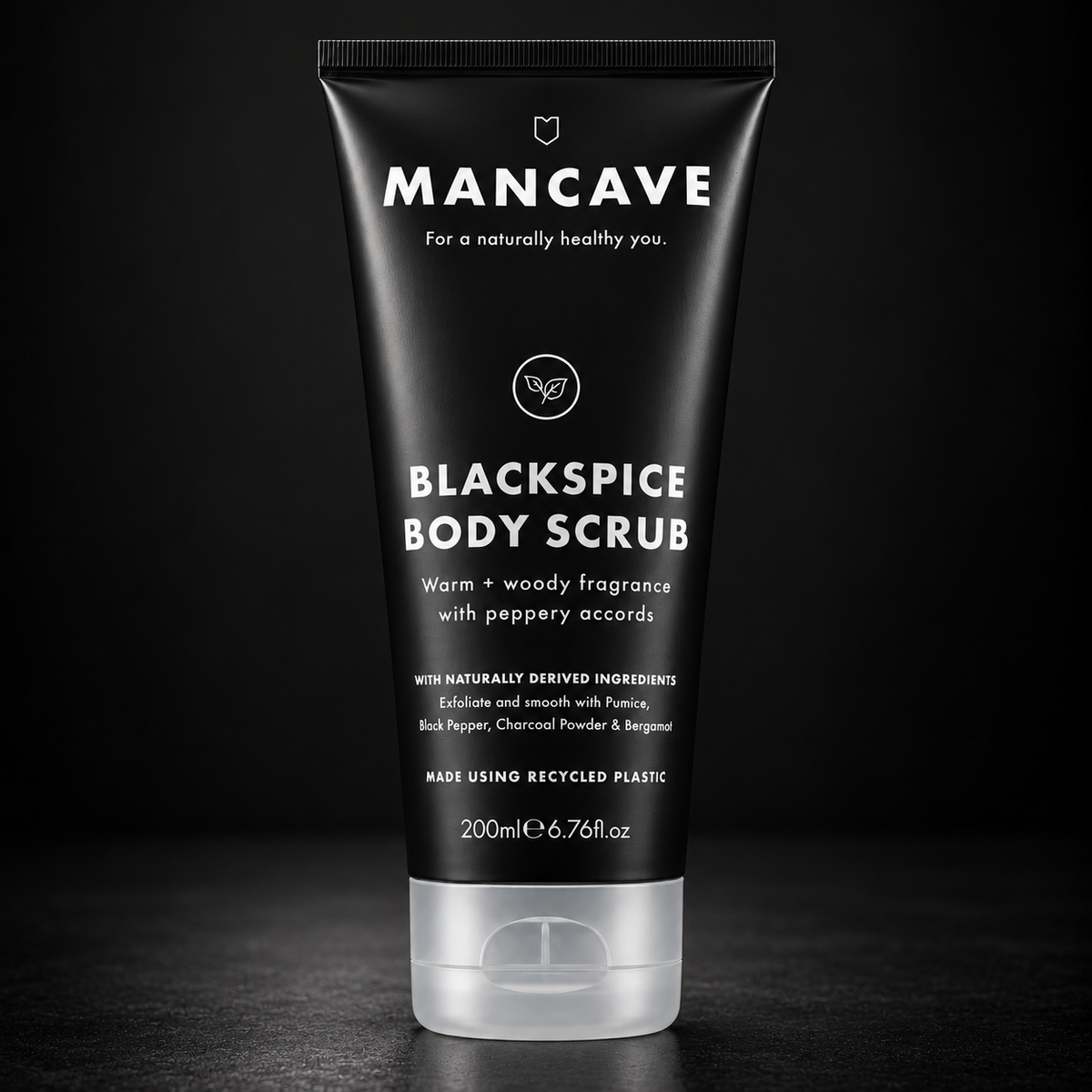 ManCave BlackSpice Body Scrub 200 ml på mørk bakgrunn